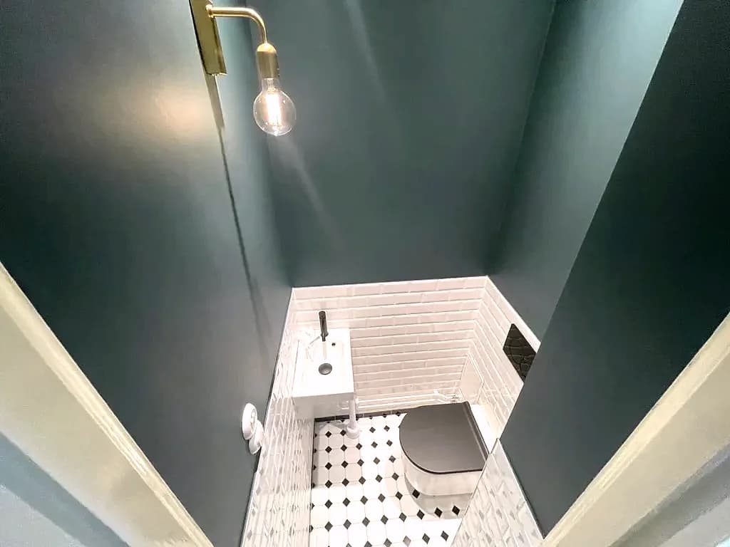 Vägglampa i mässing och vägghängd toalett