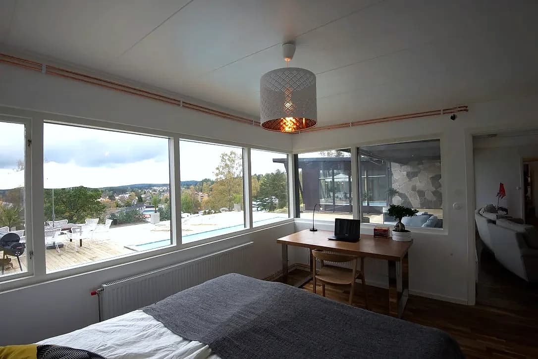 Sovrum med fönster mot trallen och poolen