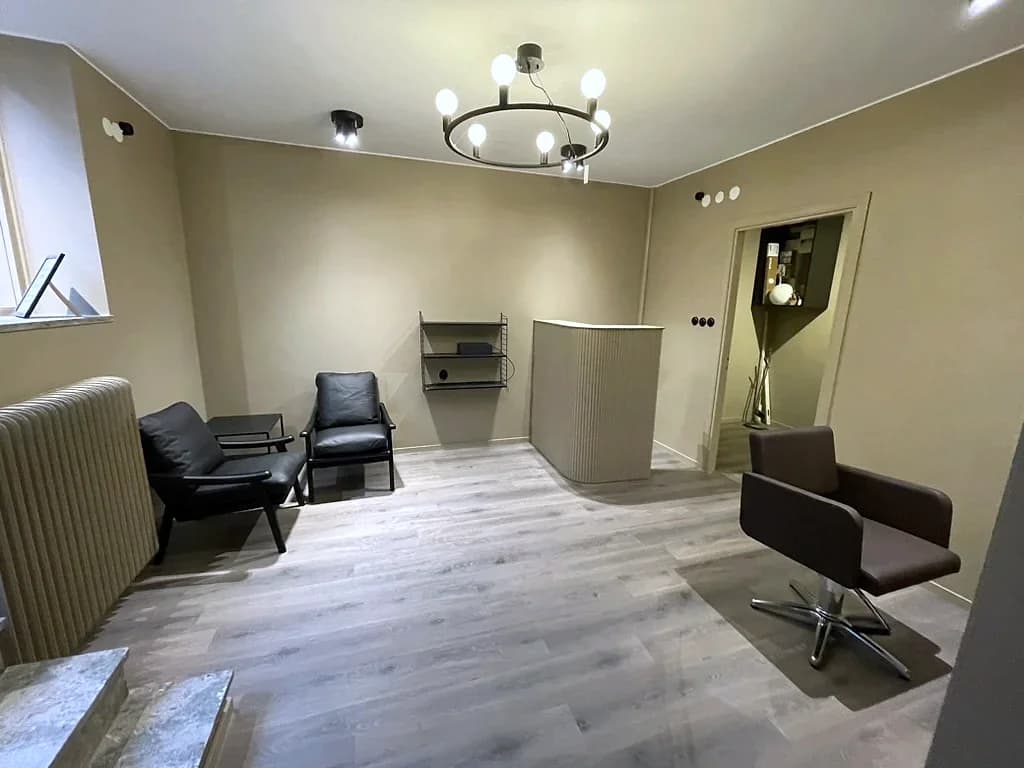Reception och vänthörna i salongens varma färgskala